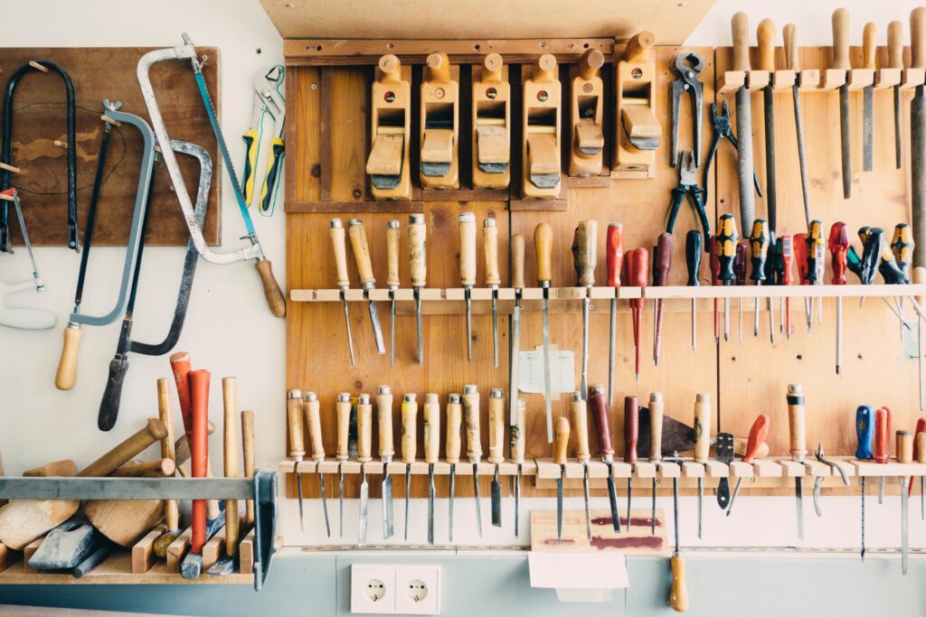 Chisels, saws, and other wood working tools hanging on a wall