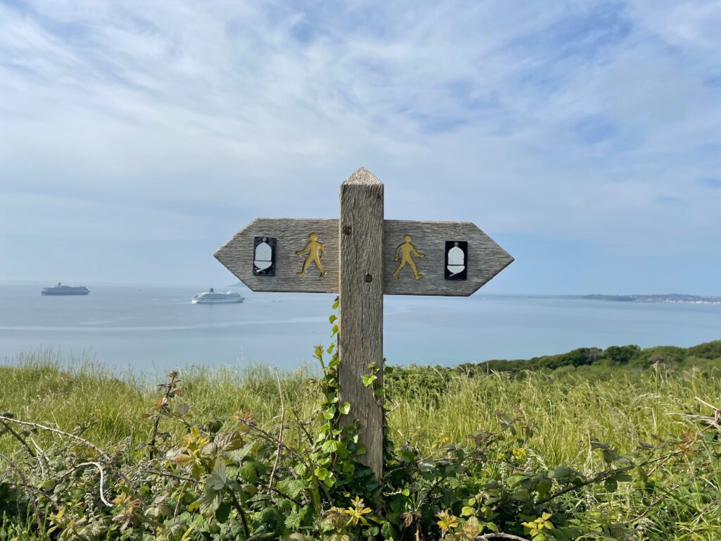 Wooden sign at a T in the road, pointing to paths leading left and right